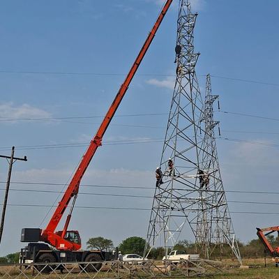 Mobile crane and crew erecting a steel transmission tower